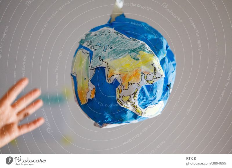Die Welt zum Greifen nah; Pappwelt Erde Pappmodel Erde Pappmaché Model Modelbau Maßstab Fälschung Hand greifen Ozean Kontinente blau Wasser Globus Schulprojekt