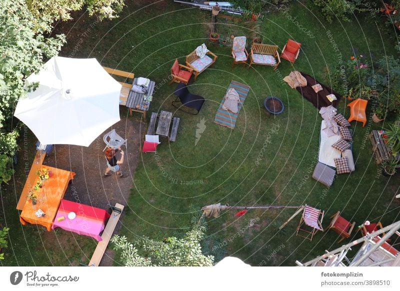 Blick von oben in einen Garten mit Tischen, Stühlen und Matratzen für eine Gartenparty Gartenfest Sommerfest Fest Party Gäste leer vorbereitet gerichtet
