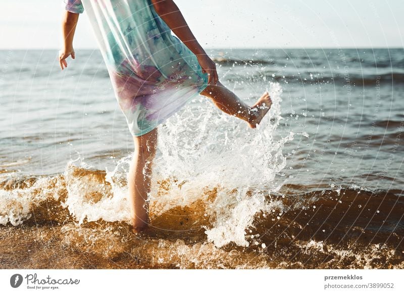Mädchen, das seine Freizeit damit verbringt, in den Sommerferien am Strand ins Meer zu springen aufgeregt frei genießen positiv Sonnenuntergang Emotion