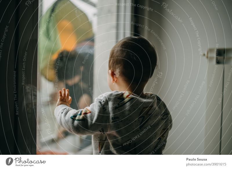 Kind beobachtet Mutter durch das Fenster Kindheit Kleinkind Kaukasier Rückansicht Tag Familie & Verwandtschaft Mensch 1-3 Jahre Farbfoto Lifestyle zu Hause