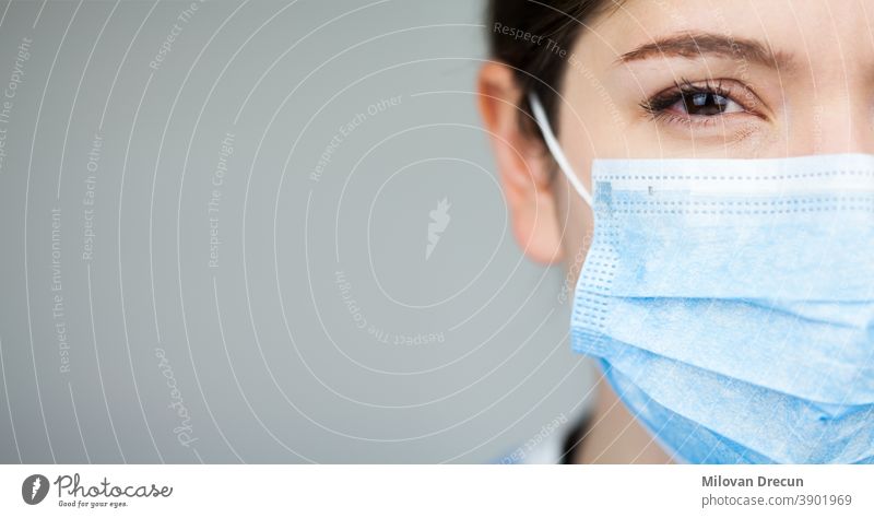 Nahaufnahme des Gesichts einer Ärztin des britischen NHS EMS, die eine blaue PSA-Schutzmaske trägt,COVID-19 Coronavirus-Krankheit,globaler Ausbruch einer Pandemie,tödliche SARS-CoV-2-Epidemie,Kopierfeld auf der linken Seite des Rahmens