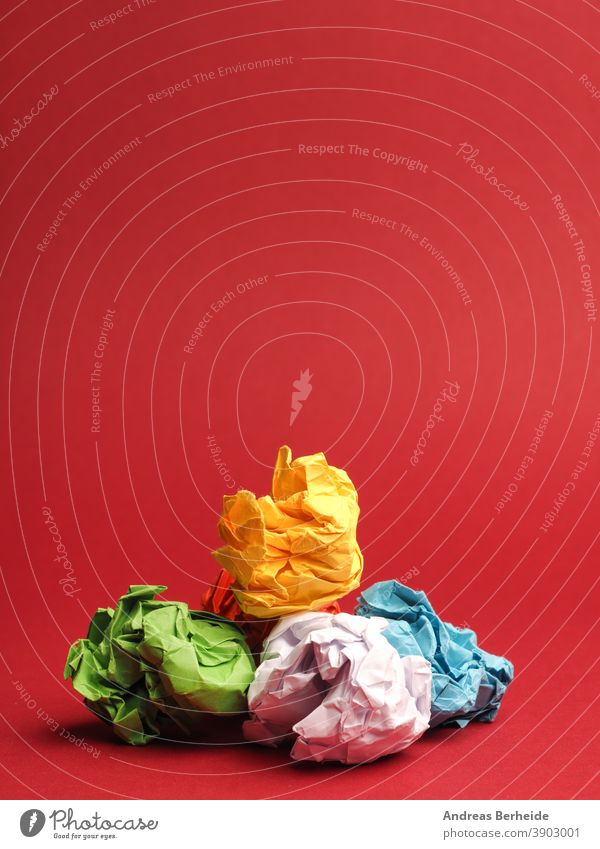 Bunte zerknitterte Papierkugeln auf rotem Studiohintergrund Errungenschaft Ball Tafel Brainstorming hell Knolle Business Konzepte Kreativität Design Fundstück