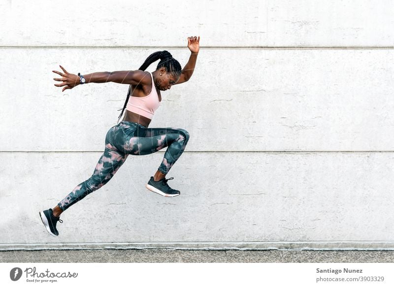Afrikanisch-amerikanischer Athlet Sprinter springend entschlossen muskulös Afro-Look Amerikaner Beginn Ehrgeiz Motivation Bewegung dynamisch Training Übung