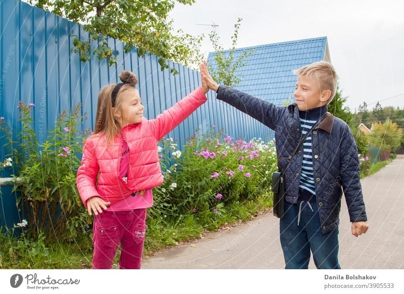 High Five. Fröhliche Kinder grüßen sich im Freien. Bild mit selektivem Fokus Natur Person Junge Lächeln Emotion Feiertag Urlaub sonnig Lifestyle Gesundheit