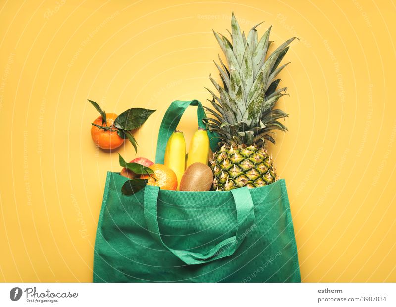 grüne Einkaufstasche mit verschiedenen Früchten, Ananas, Bananen, Orangen, Kiwis und Äpfeln Obstladen Saft Zutaten Veganer Produkte kiwis Apfel Diät Bestandteil