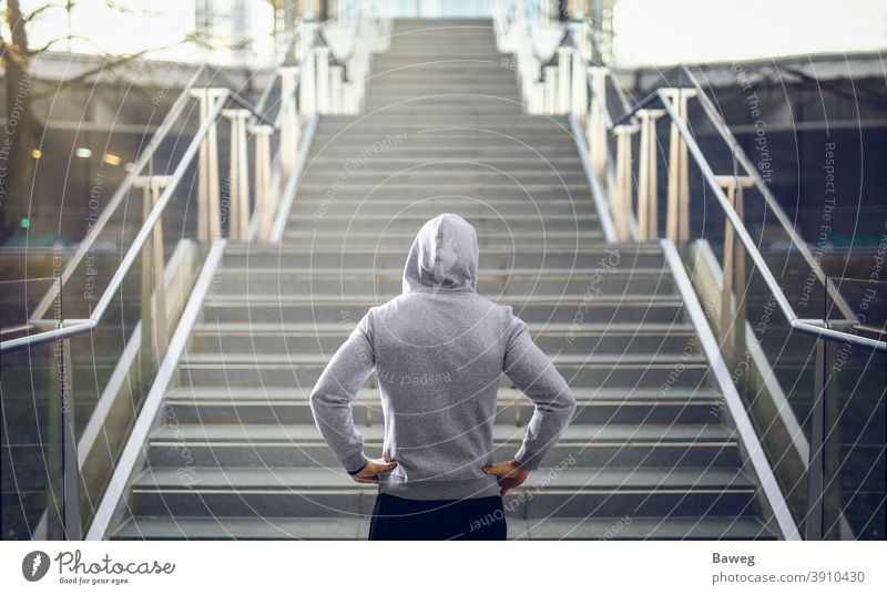Mann im Kapuzenpulli bereitet sich auf Treppenlauf vor. rennen im Freien Textfreiraum Diät disziplinieren Energie Fitness Gesundheit außerhalb Kraft Sport