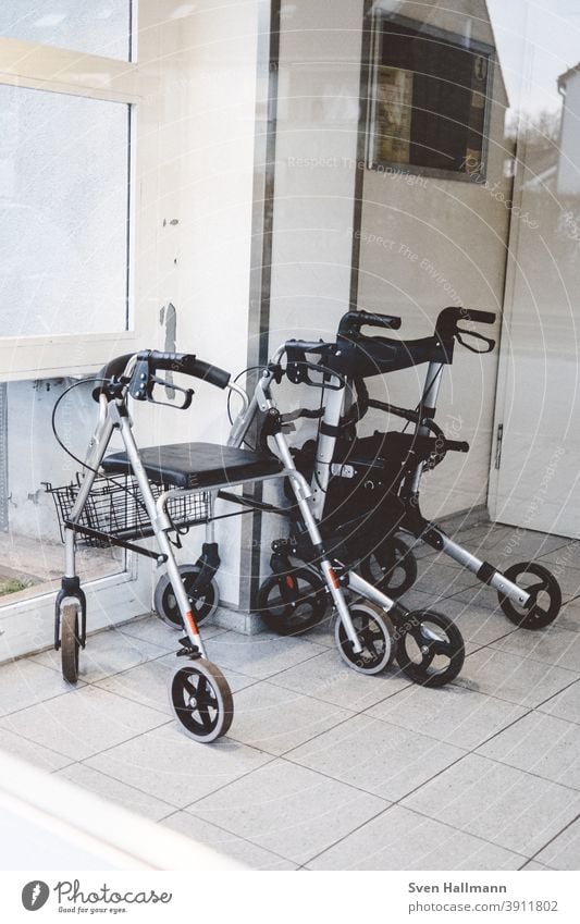 Zwei Rollatoren stehen im Hausflur Gehhilfe Senior Mobilität alt Außenaufnahme Handicap Hilfsmittel Einsamkeit Farbfoto Tag Gesundheitswesen Alter festhalten