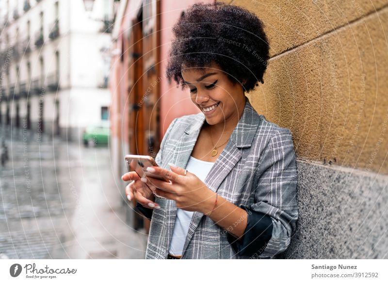 Hübsche Afro Frau mit Telefon Afro-Look Porträt schwarze Frau per Telefon Straße Stadtleben Funktelefon Smartphone benutzend Mitteilung Technik & Technologie