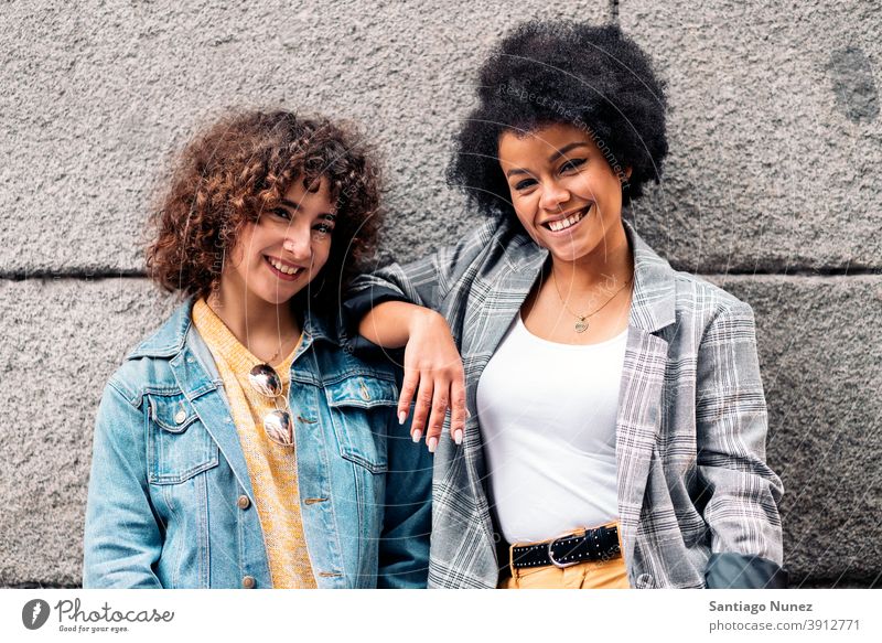 Cool Afro Mädchen und Freund lächelnd Frauen in die Kamera schauen Straße multiethnisch Afro-Mädchen Kaukasier Porträt Spaß haben Vorderansicht Freunde