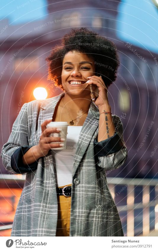 Glücklich Afro Frau mit Telefon Stehen per Telefon Telefonanruf Aufruf Tasse Kaffee Vorderansicht Afro-Look Porträt schwarze Frau Straße Stadtleben Funktelefon