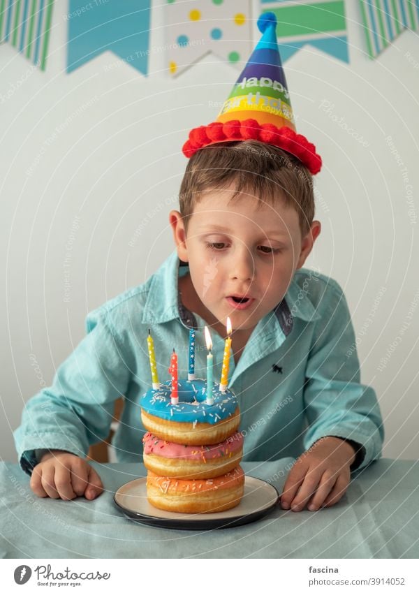 Kind bläst die Kerze auf Geburtstag Donuts Kuchen aus Schlag Krapfen Junge Hände fünf Jahr sein wenig Halt Teller Doughnut Spaß fünf Jahre alt Geburtstags-Donut