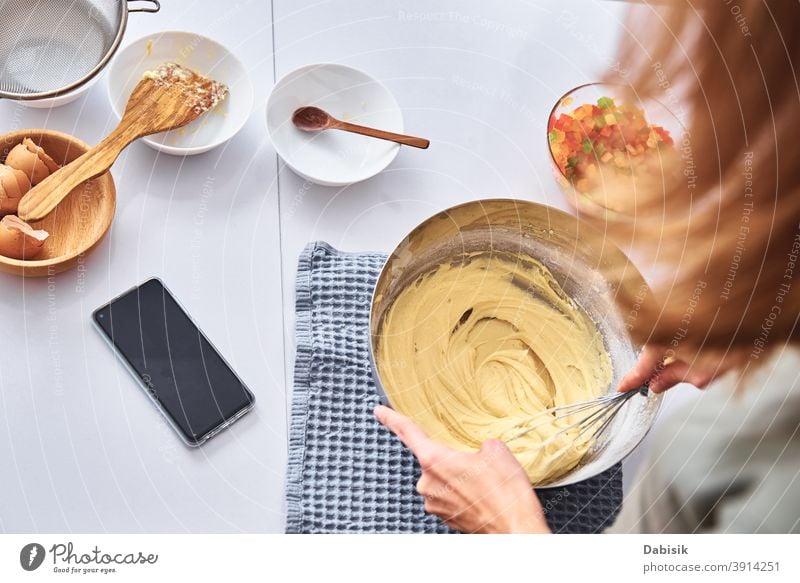 Frau in der Küche beim Backen eines Kuchens. Hände schlagen den Teig mit dem Mixer Essen zubereiten Koch Rezept Zutaten Lebensmittel Person heimwärts Kaukasier