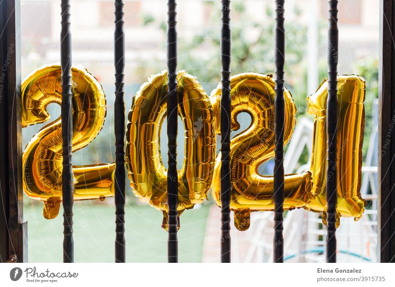 Goldfolie Luftballons Zahl 2021 hinter Bars eingesperrt Anfang des Jahres. Coronavirus Krise Konzept. Ballons Gefängnis grenzt  ein. Einsperrung Start gold