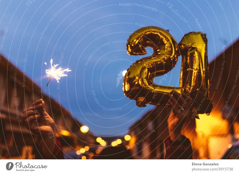 Feiern mit Goldfolie Ballons Ziffer 21 und Wunderkerze in der Nacht. Frohes neues Jahr 2021 Feier. zählen Jahre Funkelt Glückwünsche glänzend funkeln Konzepte