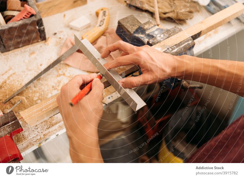Crop Holzarbeiter mit Metallwinkel in der Werkstatt Tischlerin Zimmerer Winkel Mann Holzarbeiten Schreinerei Schiffsplanken männlich Spielfigur Kunsthandwerker