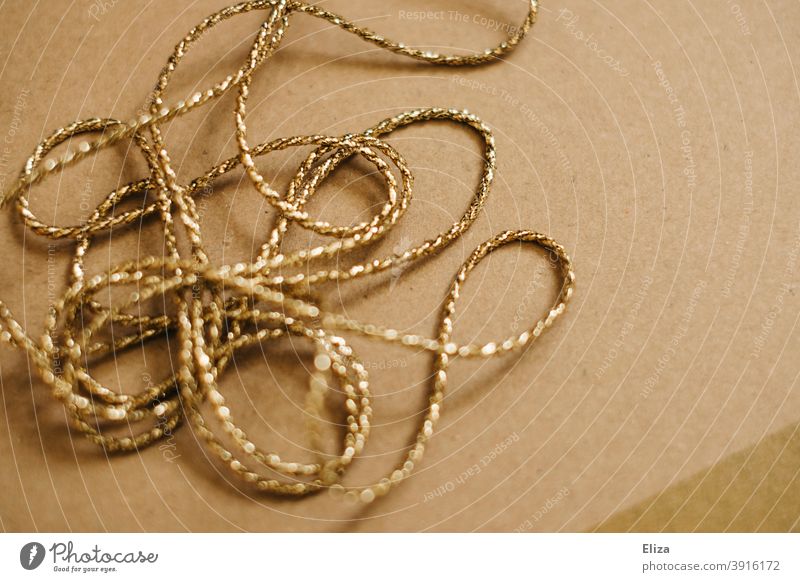 Goldene Kordel Schnur golden Geschenkband braun Paketschnur glitzernd chaotisch verheddert verschlungen