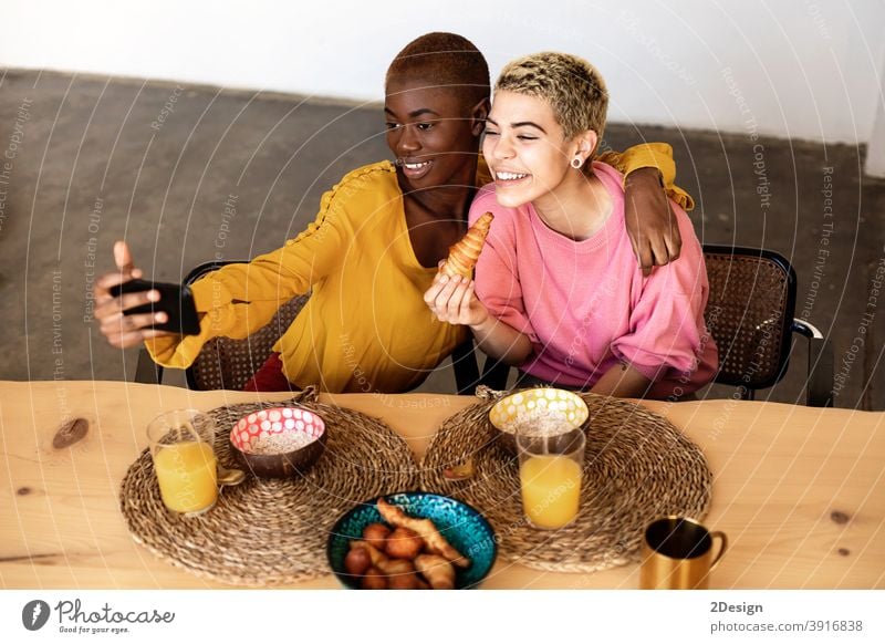 Schöne junge beste Freundin Frauen nehmen selfie mit einem Smartphone und lächelnd, während mit einem Frühstück zu Hause Selfie Freundschaft häusliches Leben