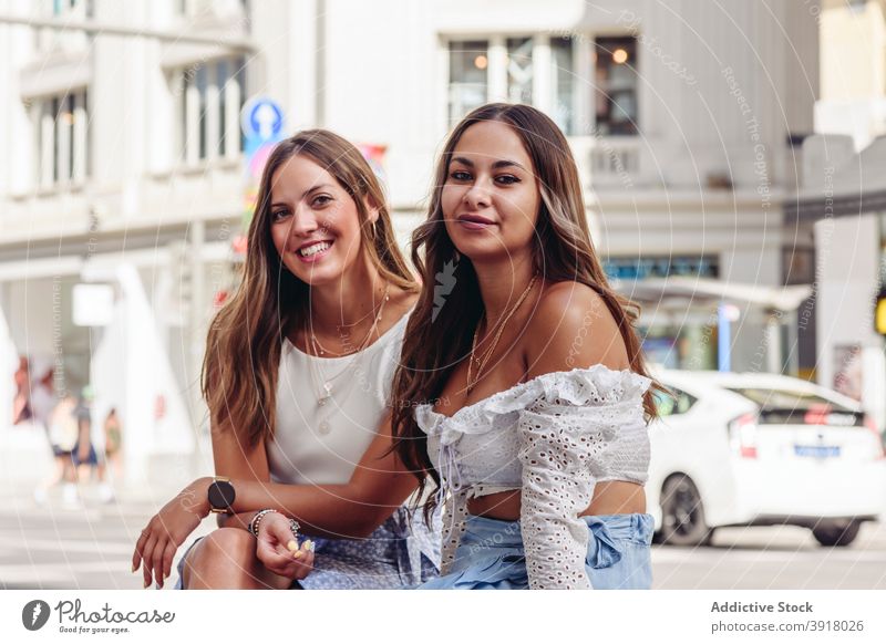 Glückliche junge Freundinnen ruhen auf Stadt Straße Zusammensein urban Sitzung heiter positiv bester Freund Frauen gleich Partnerschaft Lifestyle Inhalt
