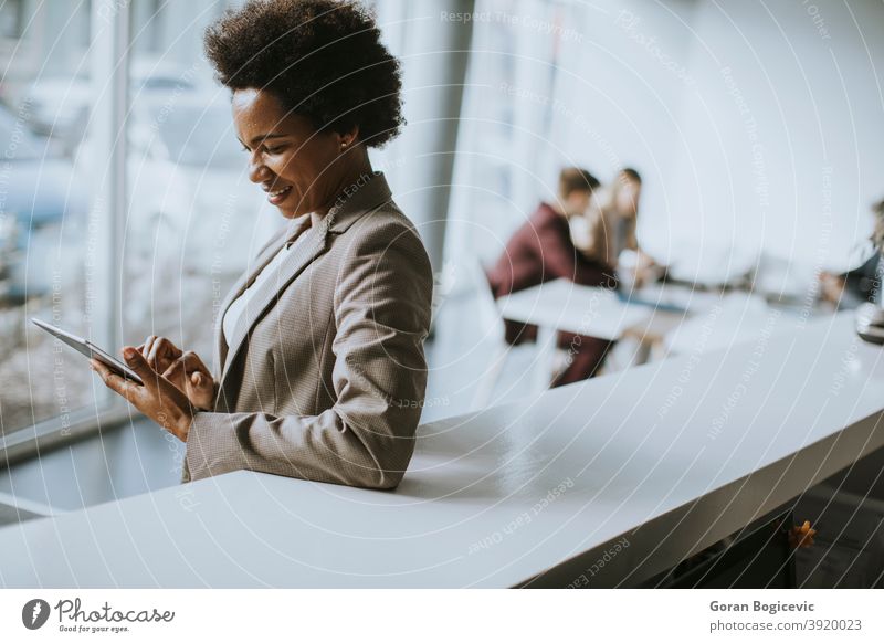 Afroamerikanische Geschäftsfrau stehend und mit digitalem Tablet in einem modernen Büro Erwachsener Afrikanisch Afro-Look Amerikaner schön schwarz Business