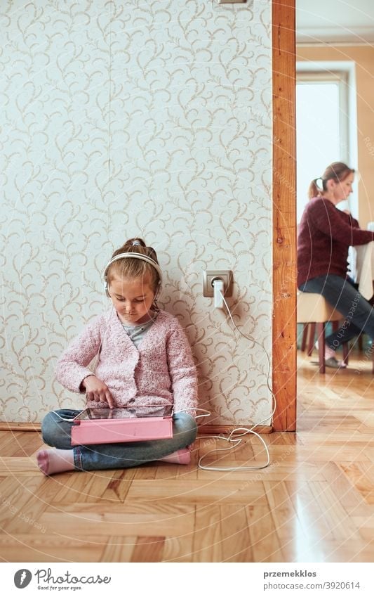Kleines Mädchen im Vorschulalter lernt online Rätsel lösen und spielt zu Hause Lernspiele auf Tablet Aufmerksamkeit Bett Schlafzimmer Kaukasier Kind Kindheit