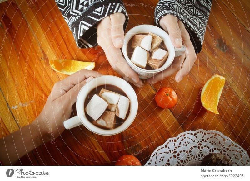 Teilen einer Tasse heißer Schokolade mit Marshmallow am Weihnachtsmorgen Silvester Zusammengehörigkeitsgefühl menschliche Verbindung heißes Schokoladengetränk