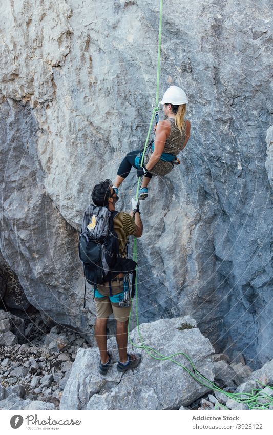 Frau mit Lehrer steigt auf felsigen Berg Aufsteiger Felsen Bergsteiger aufsteigen Aufstieg Berghang aktiv extrem Training Seil Freund Ausbilderin