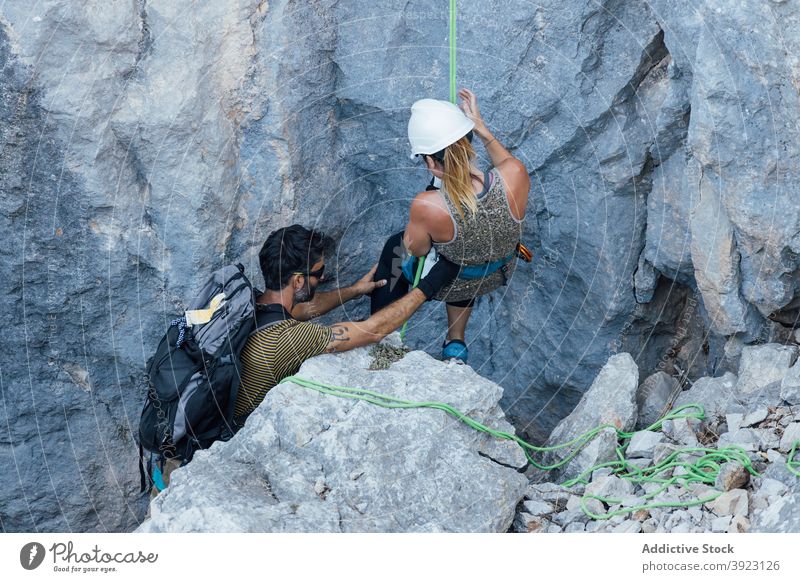 Bergsteiger bereiten sich auf die Besteigung des felsigen Hangs vor Aufsteiger Paar aktiv vorbereiten Sicherheit Seil Kabelbaum Felsen Berge u. Gebirge