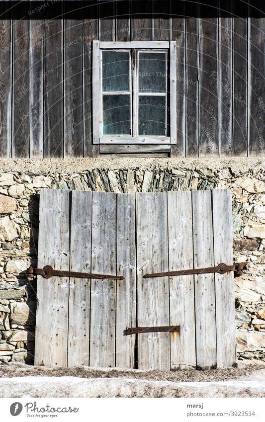 Zeitgeschichte | Früher war alles Besser. Fassade einer alten Scheune, mit zweiflügeligem Holztor und einem Fenster im oberen Bereich. Steinmauer Mauer Torbogen