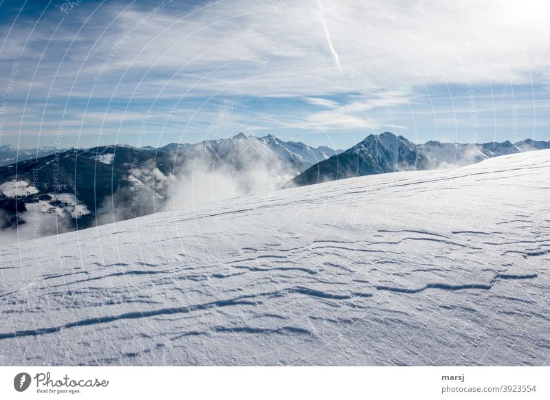 Windgeformte Schneedecke mit der Planai und mehreren Berggipfeln im Hintergrund Schneebedeckte Gipfel bewölkt Himmel Landschaft Schönes Wetter Alpen