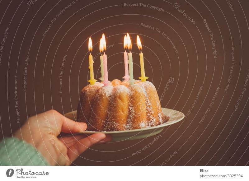Hand hält einen Geburtstagskuchen mit brennenden Kerzen Geburtstagskerzen Kuchen happy Birthday Geburtstagsfeier Guglhupf Feste & Feiern Kindergeburtstag