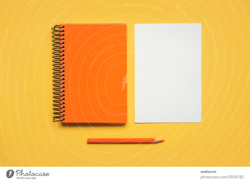 orangefarbener Spiralnotizblock mit einem Blatt weißem Papier und orangefarbenem Bleistift Notizblock Farbstift zurück zur Schule Bildung Memo Raum Seiten Text