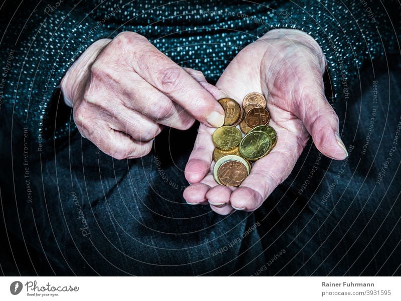 eine ältere Frau hält in ihren Händen wenige Münzen alt faltig Rentner Rentnerin Rente Armut Geld Hartgeld sparen Sparsamkeit Geldanlage Bargeld Euro Finanzen
