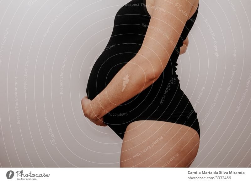 Schwangere junge Frau mit schwarzen Dessous Unterleib Erwachsener Baby Hintergrund schön Schönheit Bauch Körper Blumenstrauß Konzept Textfreiraum erwartungsvoll
