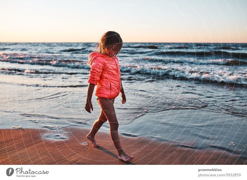 Kleines Mädchen läuft barfuß am Strand bei Sonnenuntergang frei genießen positiv Emotion sorgenfrei Natur im Freien reisen Fröhlichkeit Glück MEER Freude Sommer