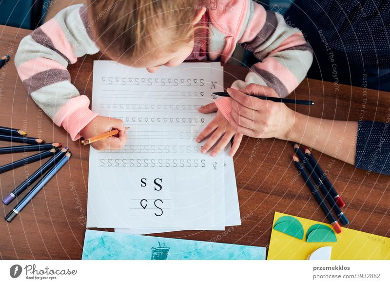 Kleines Mädchen im Vorschulalter, das mit Hilfe seiner Mutter lernt, Briefe zu schreiben Aufmerksamkeit Kaukasier Kind Kindheit niedlich Bildung lehrreich Spaß