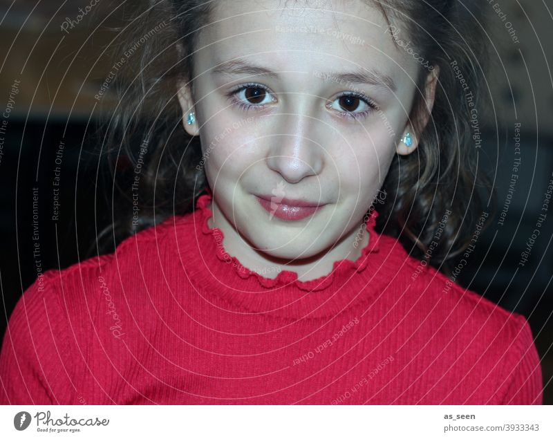 Mädchen in rotem Pullover 8-13 Jahre braune Haare braune Augen direkter Blick Lächeln selbstbewusst fröhlich angeblitzt Porträt schön Mensch Farbfoto feminin