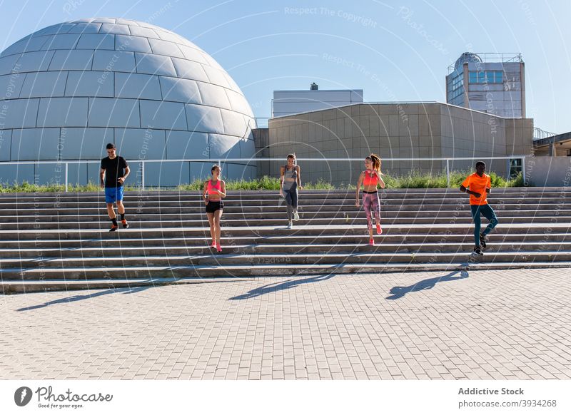 Sportler, die beim Training in der Stadt laufen Läufer Menschengruppe Zusammensein Team Einheit Herz Großstadt multiethnisch rassenübergreifend vielfältig