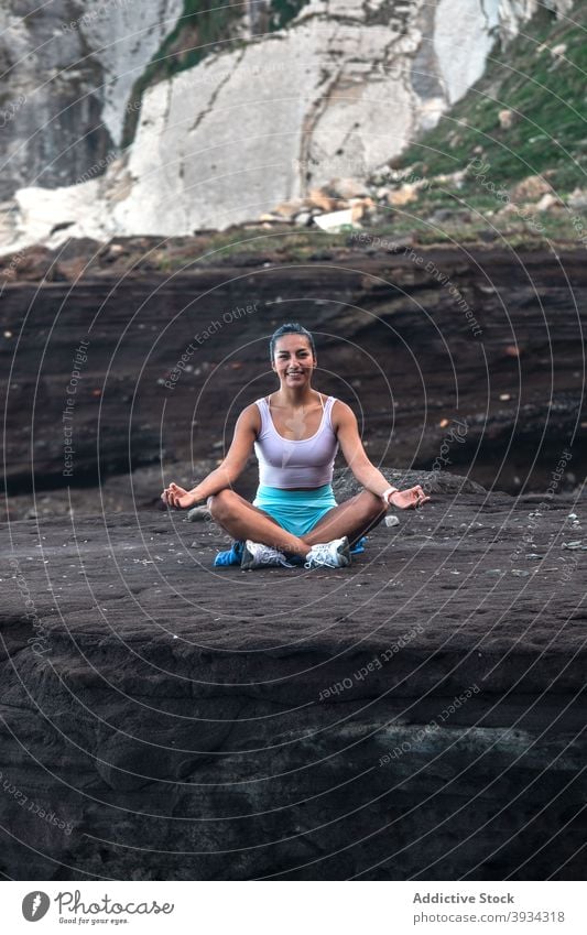 Entspannte Frau macht Yoga in Lotus-Pose am Meeresufer meditieren Strand padmasana Mudra Achtsamkeit Zen friedlich Harmonie üben Gesundheit Gleichgewicht Ufer