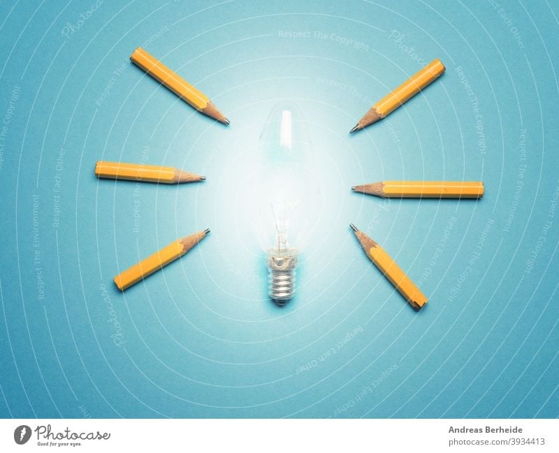 Eine leuchtende Glühbirne mit 6 Bleistiften als Lichtstrahlen, Neue Ideen oder Kreativität Konzept auf blauem Hintergrund Vielfalt Team positiv Gelegenheit