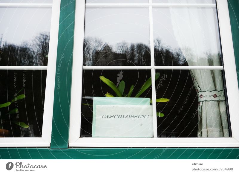 Hinter der Glasscheibe des Fensters einer Gaststätte steht auf einem Blatt Papier in großen Druckbuchstaben "GESCHLOSSEN" / Coronakrise / Prävention geschlossen