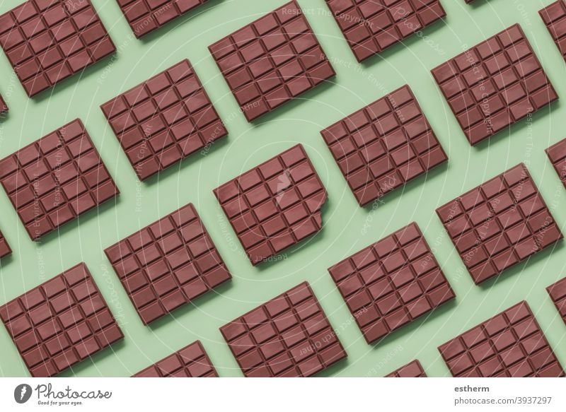 Geometrisches Muster aus Schokoriegeln und in der Mitte eine angebissene Tafel geometrisches Muster Schokolade Milchschokolade Schokoladentafel lecker