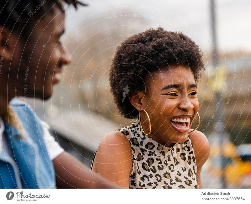 Fröhliches schwarzes Paar in trendiger Kleidung steht auf der Straße trendy heiter Hipster modern Stil Lachen Zusammensein Afro-Look jung Afroamerikaner