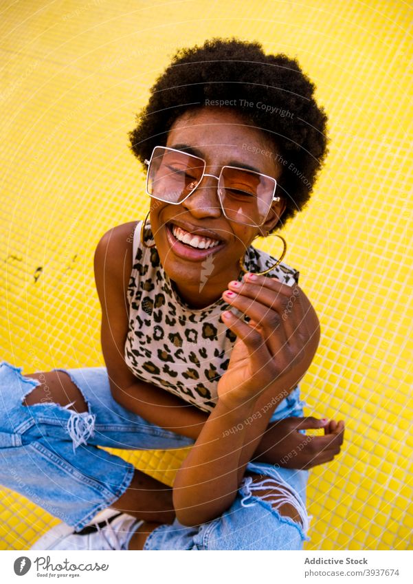 Lachende schwarze Hipster-Frau mit stylischer Sonnenbrille Stil trendy heiter Afro-Look modern jung Afroamerikaner ethnisch Optimist Brille Accessoire Design