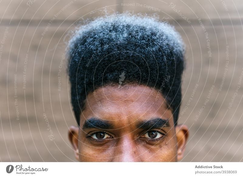 Crop schwarzer Mann mit Afro-Frisur Afro-Look krause Haare gefärbtes Haar Vorschein gutaussehend Behaarung Stil Straße männlich ethnisch Afroamerikaner