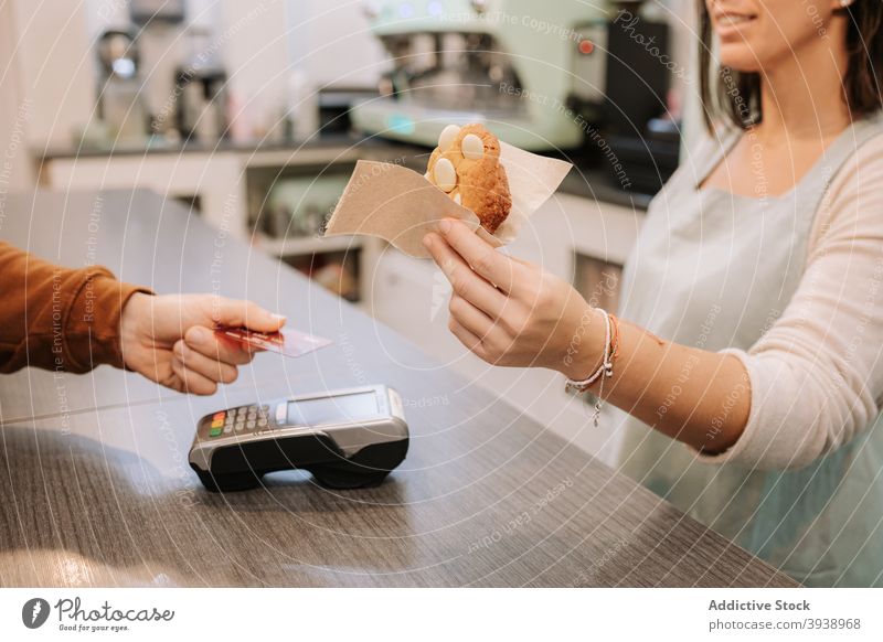Verkäufer gibt süßen Keks an Kunden in Konditorei-Café Zahlung nfc Kreditkarte berührungslos dienen Terminal Klient Lebensmittel Dessert bezahlen Kauf Postkarte
