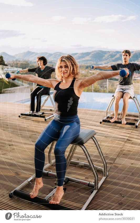 Menschen beim Pilates-Workout auf der Terrasse Training Übung Kurzhantel Stuhl heiter üben Zusammensein Lächeln Glück Menschengruppe Sport Wohlbefinden Energie