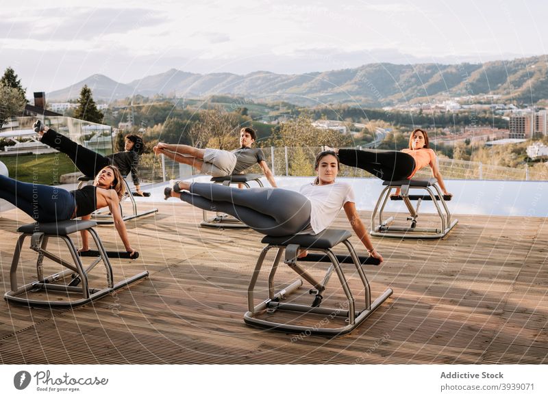 Gruppe von Menschen während des Pilates-Trainings Klasse Stuhl Übung Menschengruppe Bauchmuskeln Unterleib Unternehmen Sportbekleidung Terrasse physisch