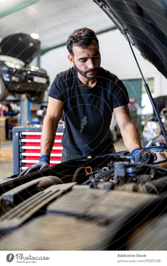 Mechaniker überprüft Automotor in der Werkstatt Mann PKW Motor Erdöl untersuchen inspizieren Techniker prüfen Dienst männlich Verschlussdeckel professionell