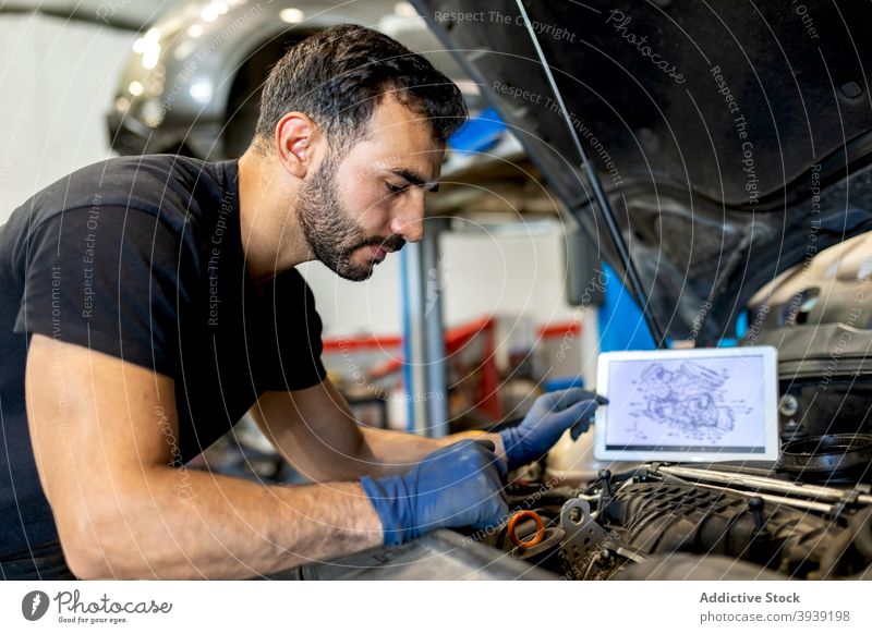 Männlicher Mechaniker, der einen Automotor im Service überprüft Mann PKW Dienst Motor untersuchen inspizieren Techniker Schema Diagramm männlich prüfen
