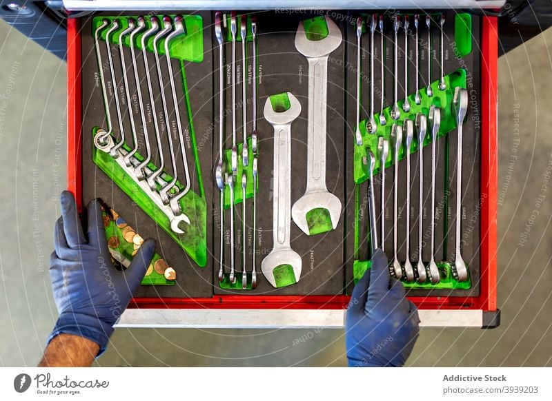 Crop-Mechaniker mit verschiedenen Werkzeugen in der Autowerkstatt Kabinett Schraubenschlüssel Mann Taste Sammlung PKW Dienst männlich Techniker Instrument